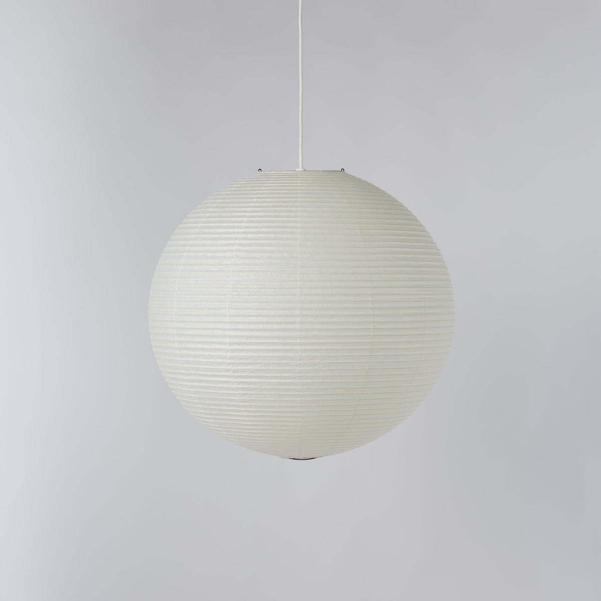 A spherical pendant light with a ribbed, paper lantern-like texture in an off-white color, suspended by a thin white cord against a neutral light gray background.