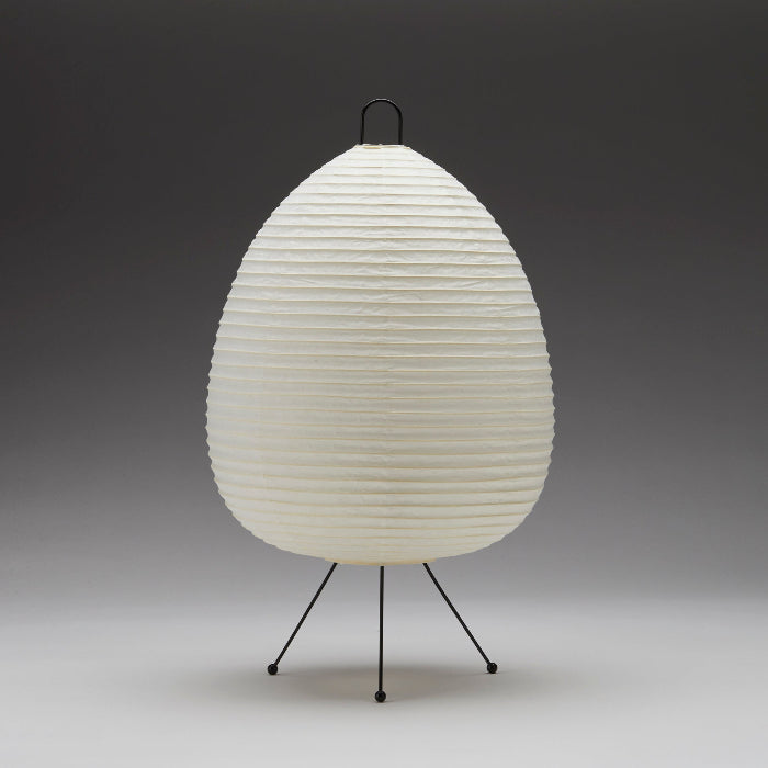 White textured lamp on a black tripod stand against a gray background