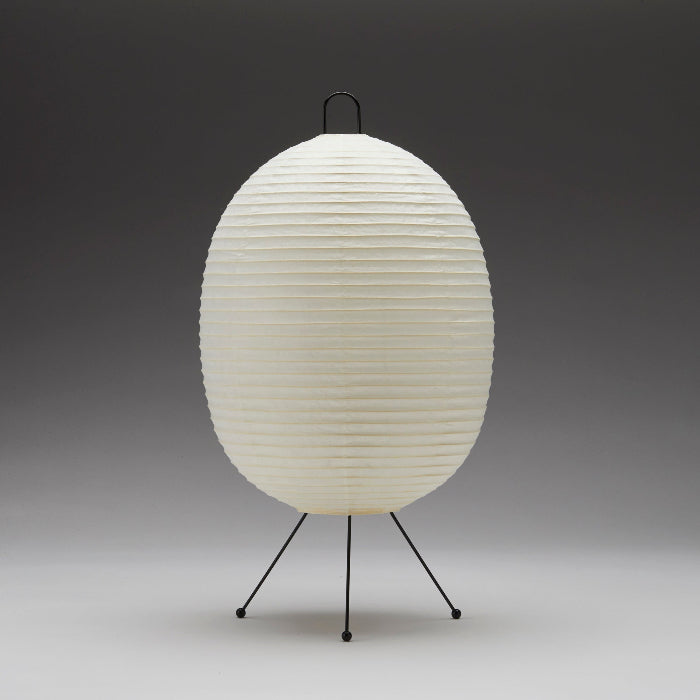 White paper lamp with black metal stand on a gray background