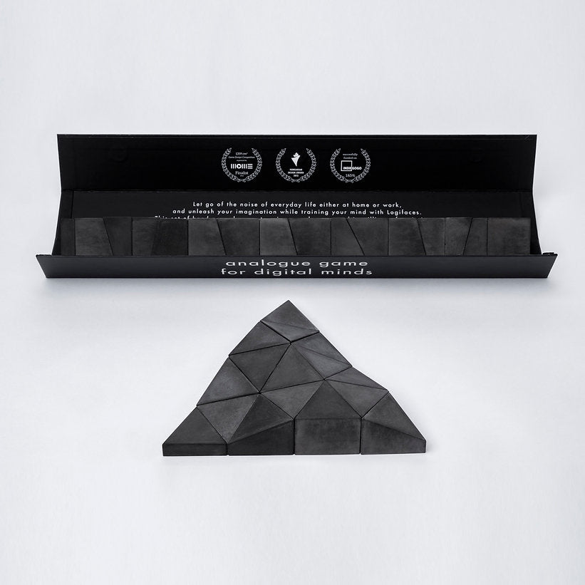 Logifaces, a geometric puzzle made of concrete triangular prisms, arranged in various configurations to form a continuous surface. The minimalist design encourages creative problem-solving and spatial thinking