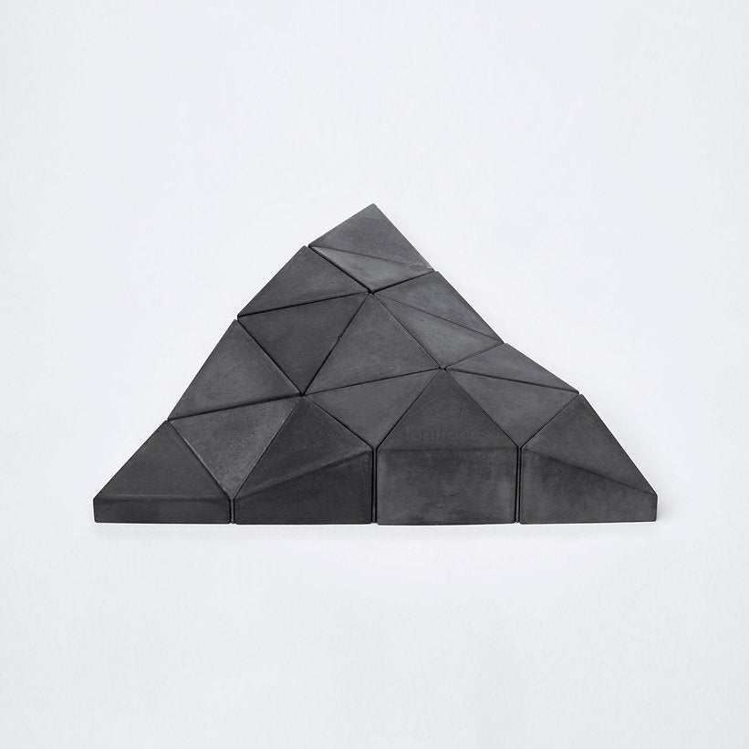Logifaces, a geometric puzzle made of concrete triangular prisms, arranged in various configurations to form a continuous surface. The minimalist design encourages creative problem-solving and spatial thinking