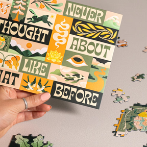 Hand holding a completed puzzle piece with motivational text, surrounded by scattered puzzle pieces on a neutral background.