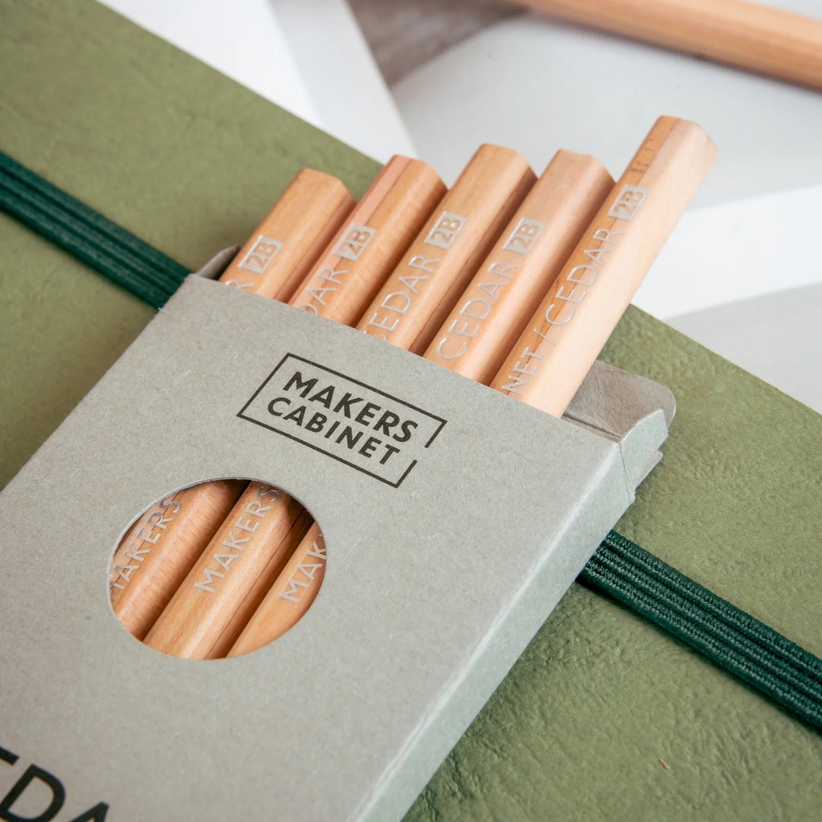 Set of wooden pencils in a 'MAKERS CABINET' box on a green surface