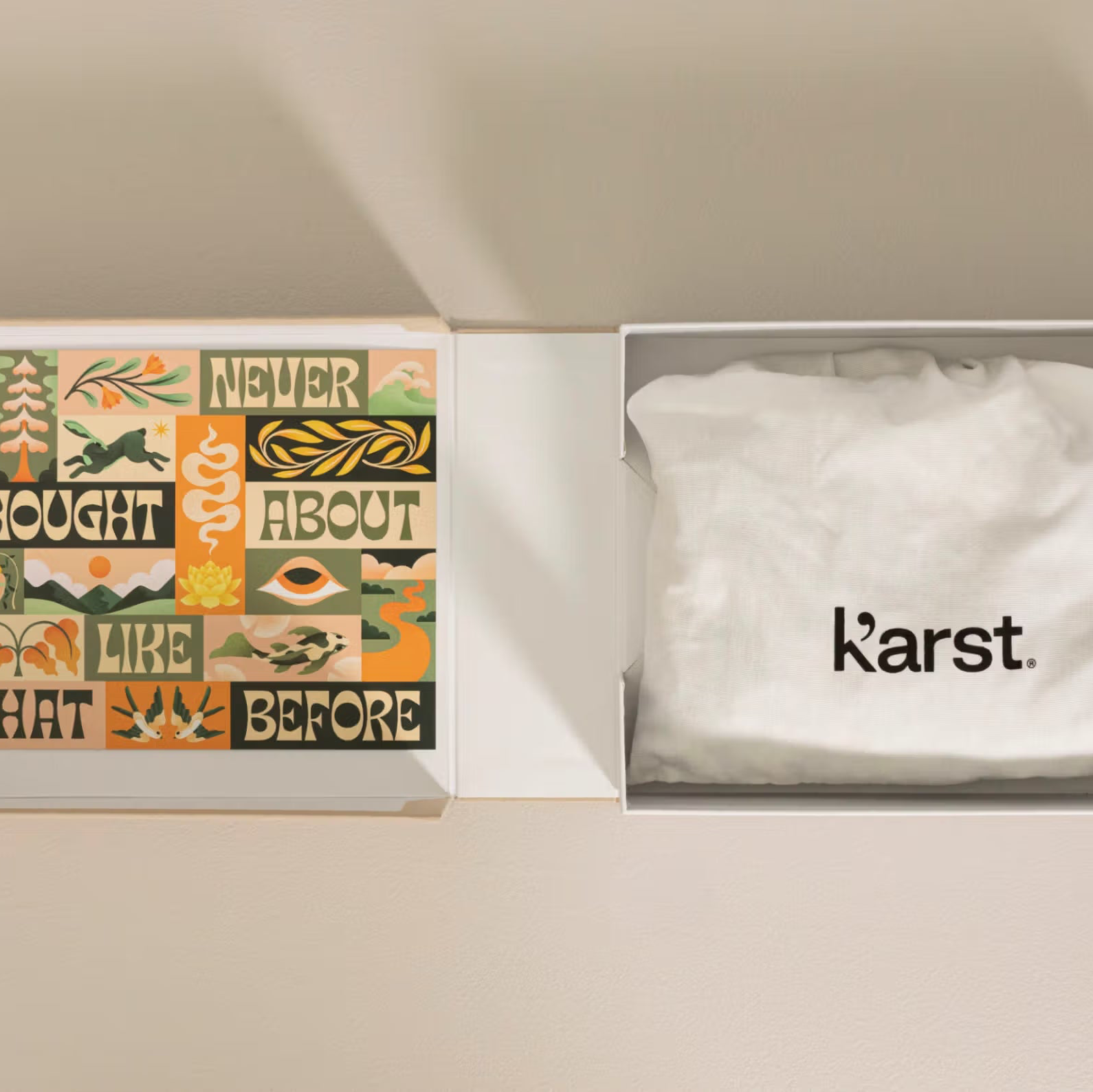 Box with a white towel and a colorful card inside, featuring the brand 'Karst'.
