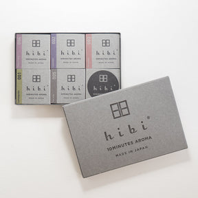 A set of six hibi 10minutes aroma incense sticks in various colors, with one gray box in the foreground and five other boxes behind it on a white background.