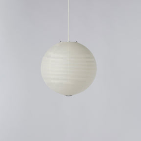 A spherical pendant light with a ribbed, pleated paper or fabric exterior, suspended by a thin white cord against a solid light gray background.