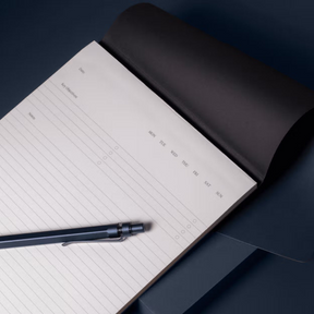 Open notebook with a pen on a dark surface