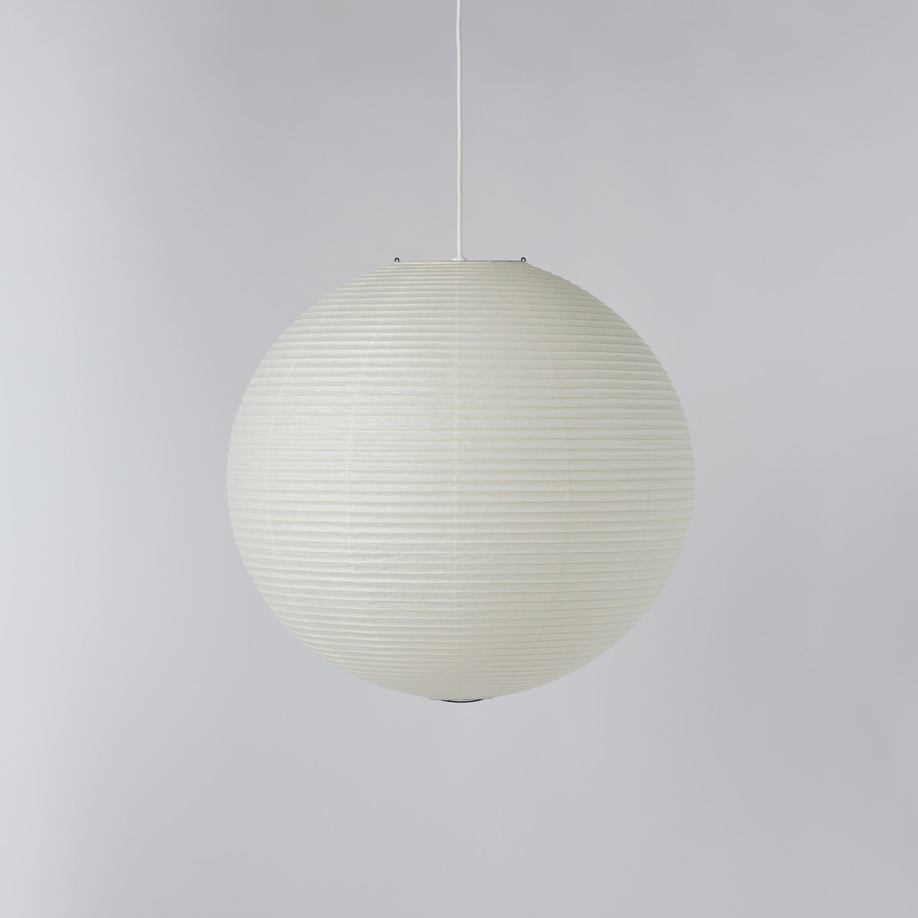 A spherical pendant light with a ribbed, paper lantern-like texture in an off-white color, suspended by a thin white cord against a neutral light gray background.