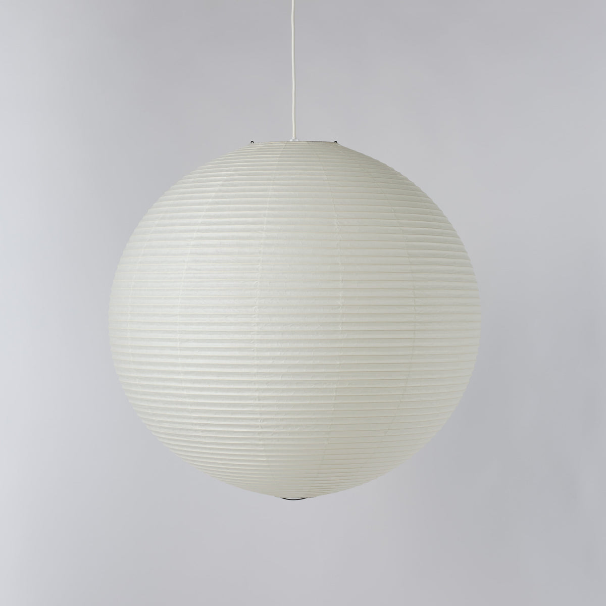 An off-white spherical pendant light with a ribbed paper lantern style, suspended by a thin white cord against a neutral light gray background.