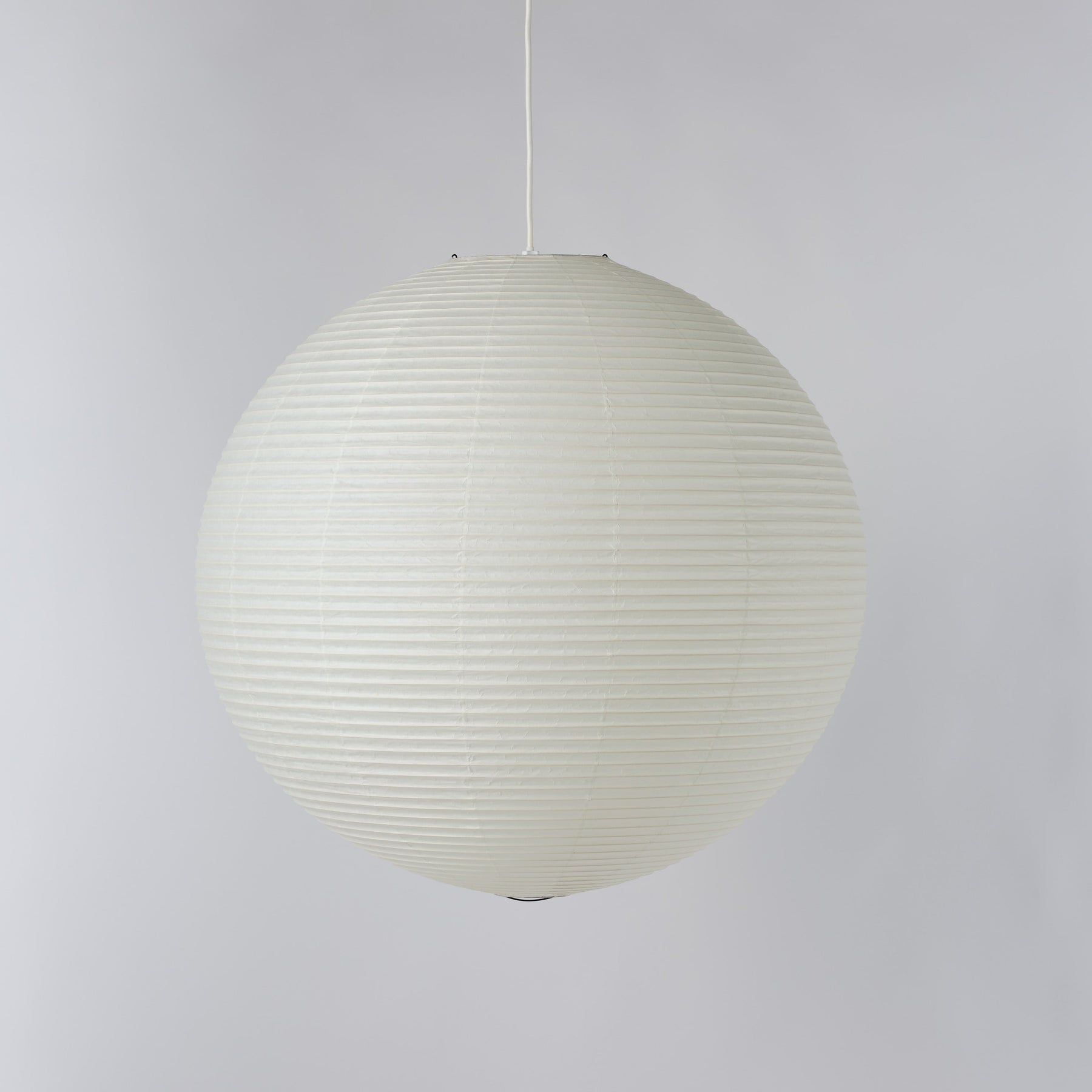 An off-white spherical pendant light with a ribbed paper lantern style, suspended by a thin white cord against a neutral light gray background.