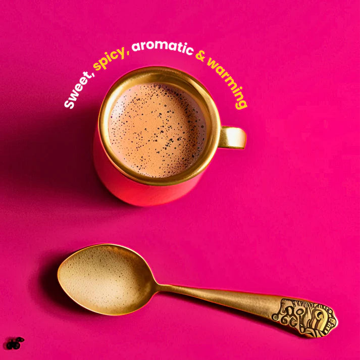 Red cup of coffee with gold spoon on a pink background
