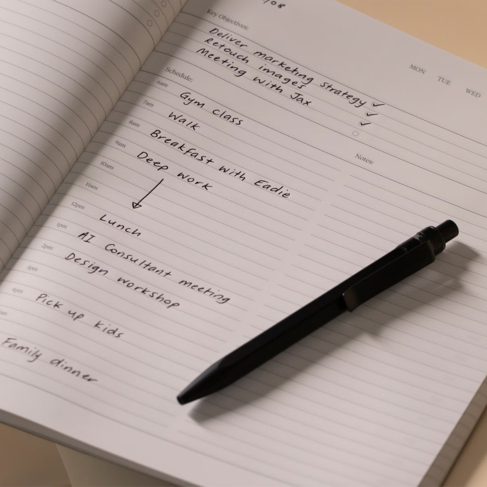 Open notebook with a pen on a beige surface