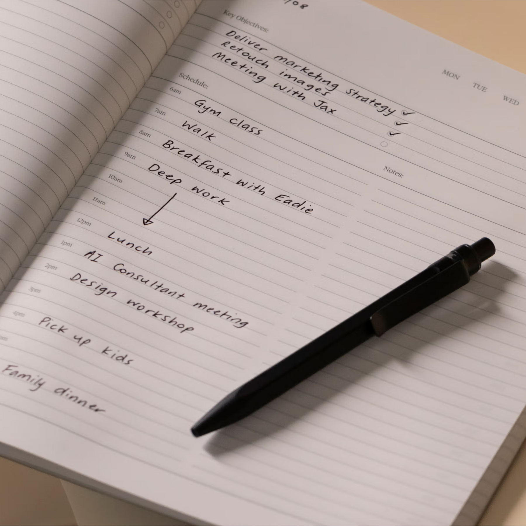 Open notebook with a pen on a beige surface