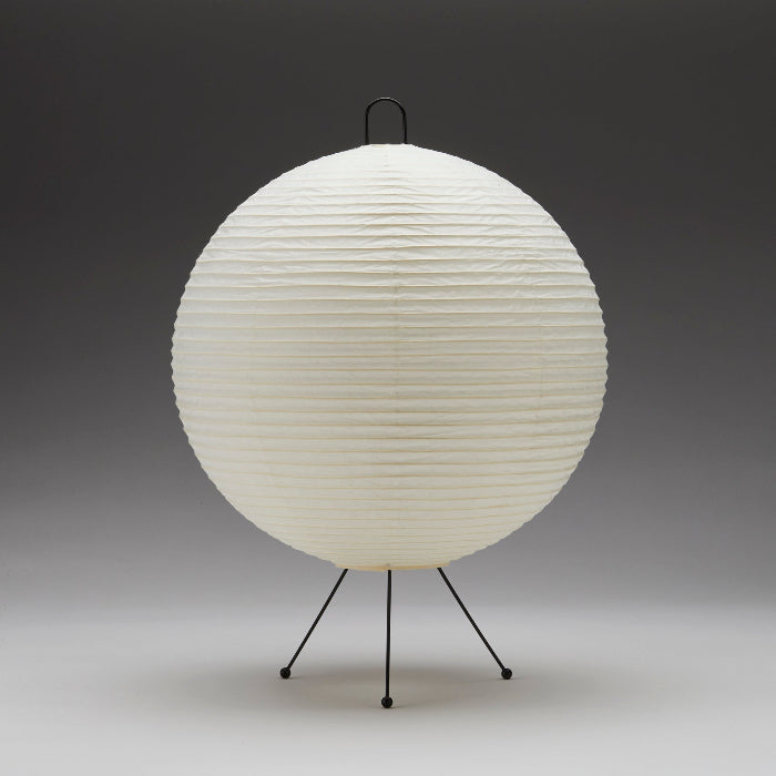 Spherical lamp with a textured white surface on a black stand against a gray background