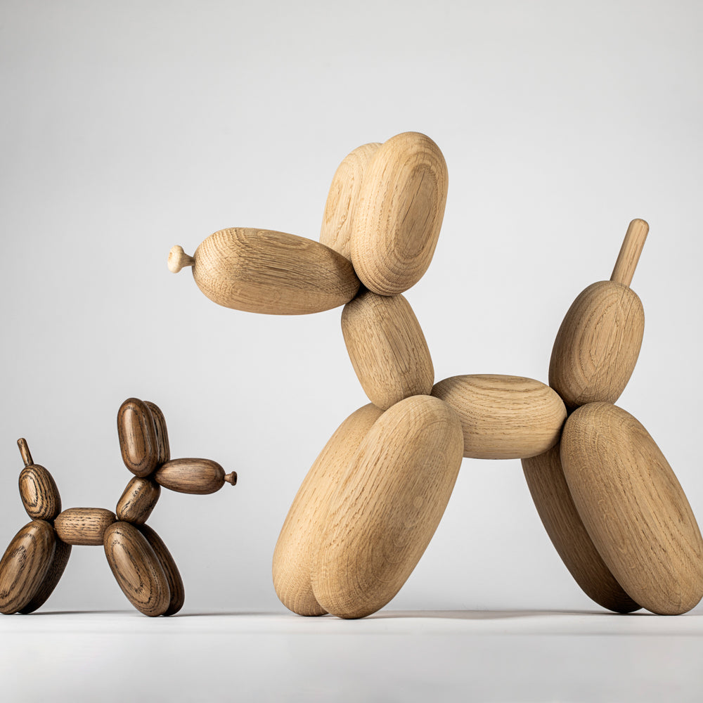 Wooden balloon dog sculptures on a light gray background