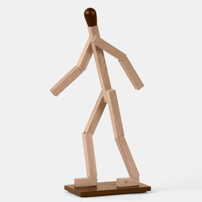 Wooden sculpture of a walking figure on a white background