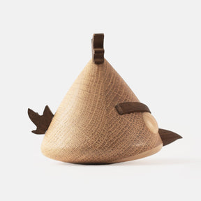 Side view of wooden figurine of an animated cartoon bird character carved from light and dark wood, featuring a triangular body shape, prominent angled eyebrows, round eye details, a small pointed beak, visible natural wood grain, and a smooth matte surface on a plain white background.