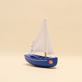 Model sailboat on a beige background
