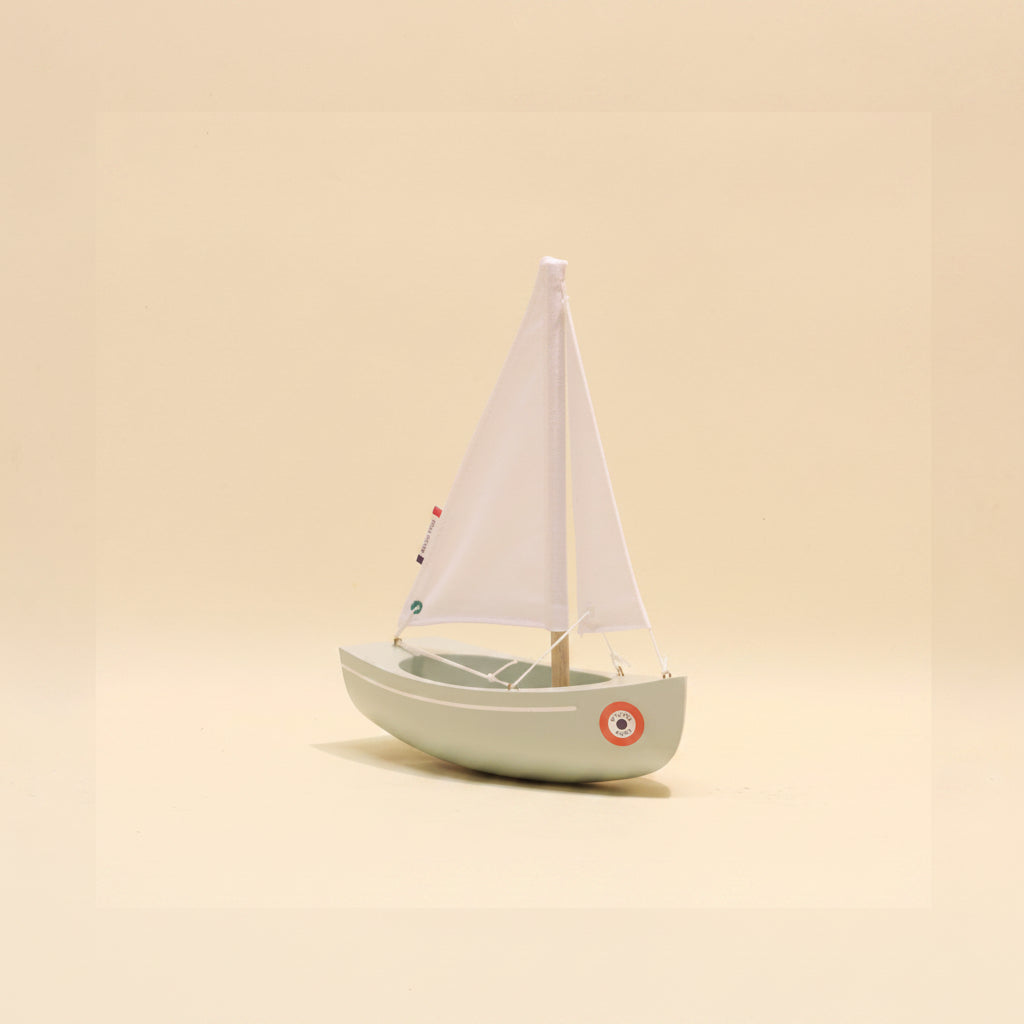 Model sailboat on a beige background