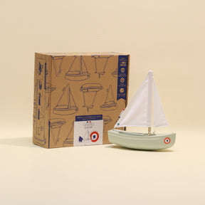 Model sailboat in front of a box with sailboat design