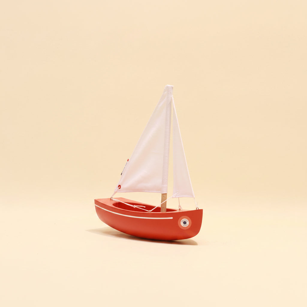 Model sailboat on a beige background