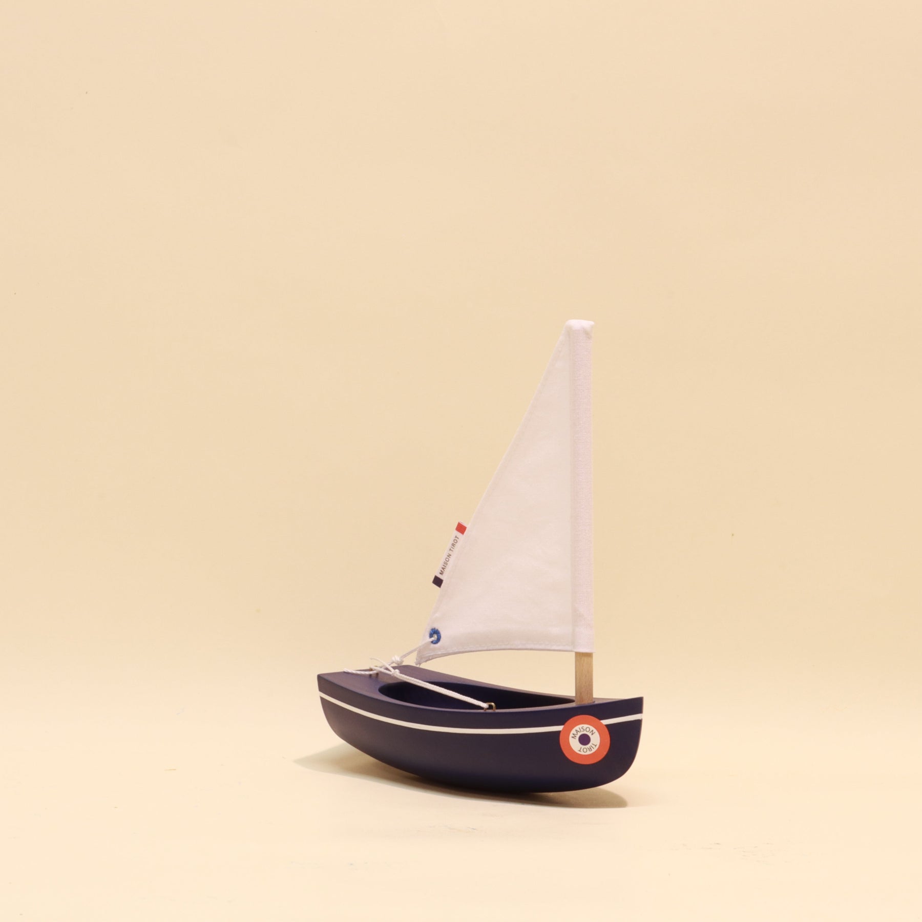 Model sailboat on a beige background