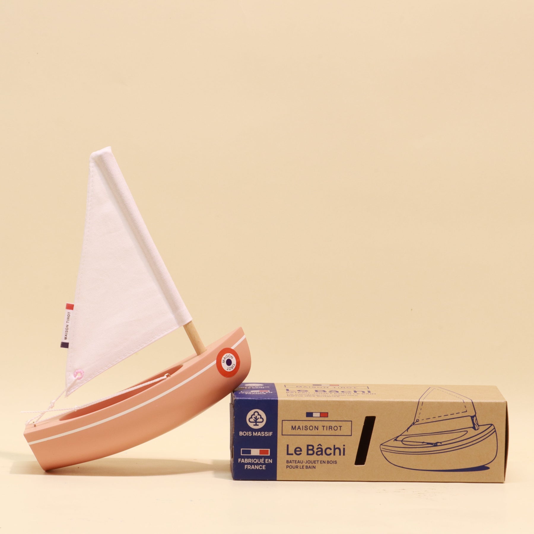 Model sailboat with a cardboard packaging box on a beige background