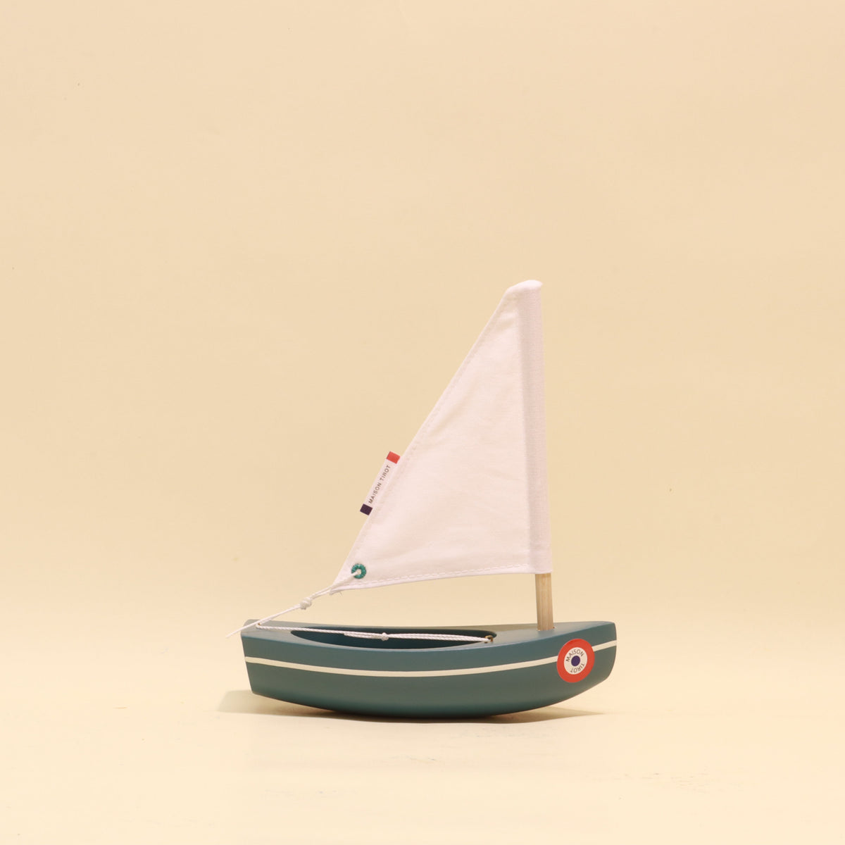 Model sailboat on a beige background