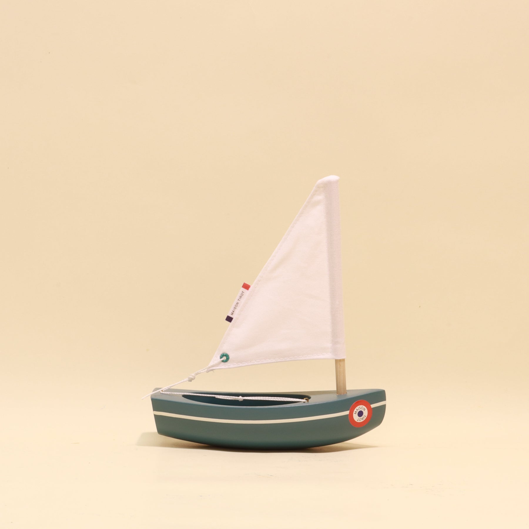 Model sailboat on a beige background