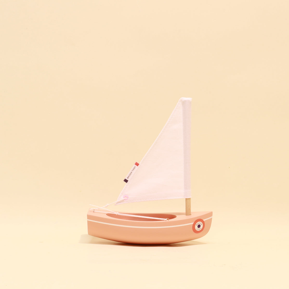 Small sailboat model on a beige background