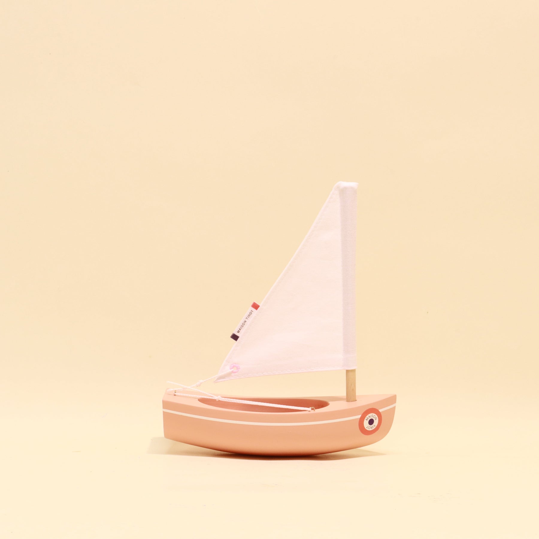 Small sailboat model on a beige background