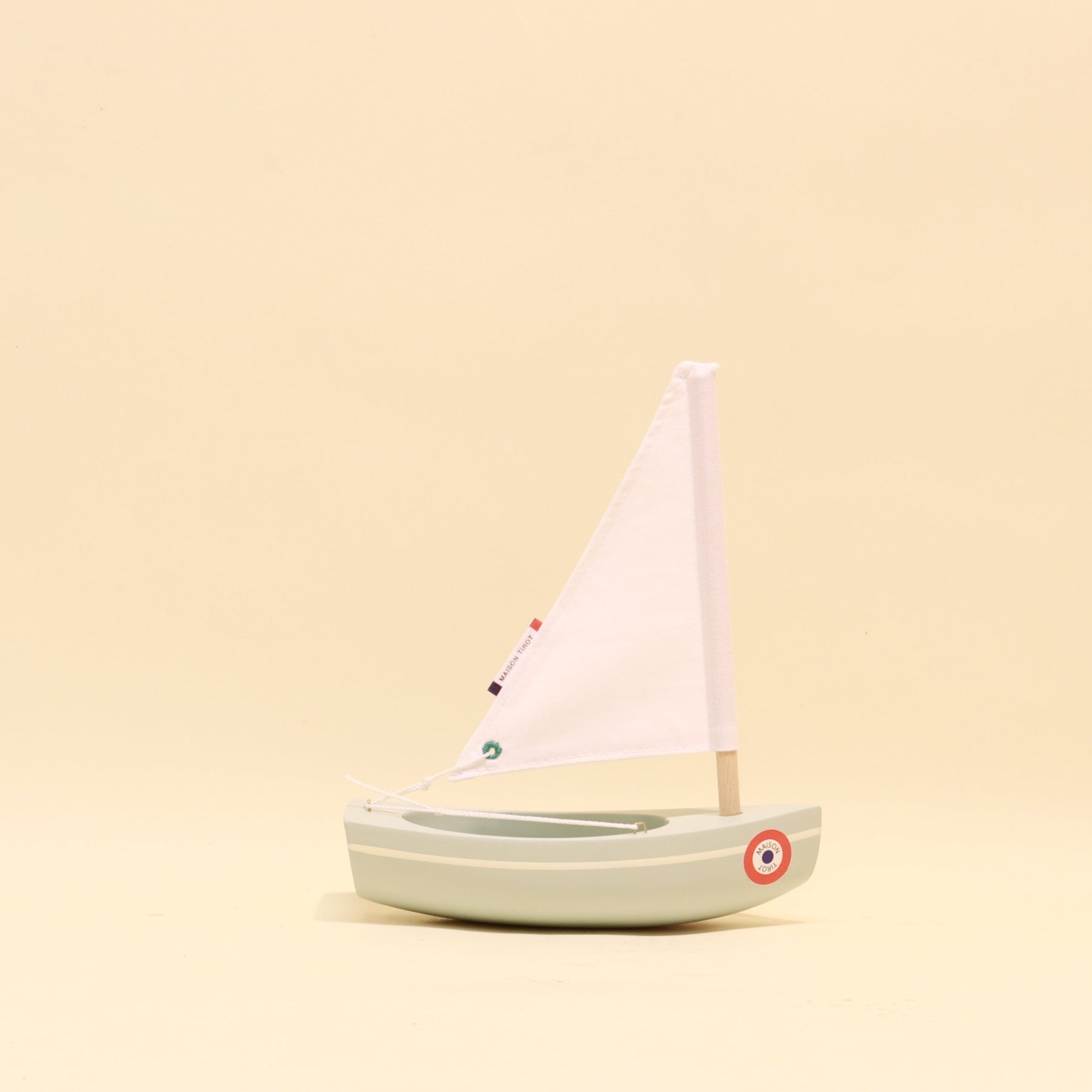 Model sailboat on a beige background