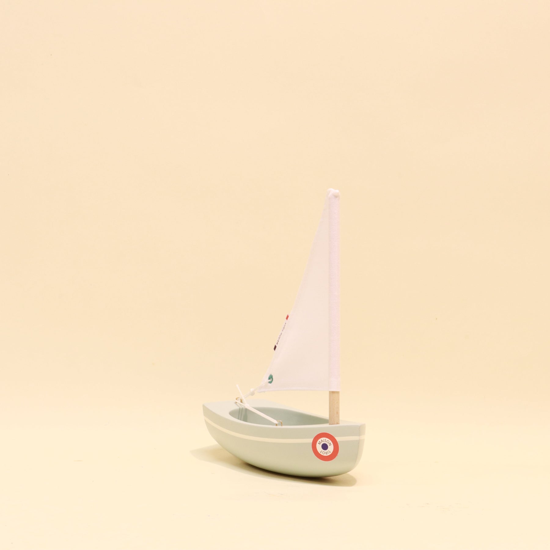 Model sailboat on a beige background