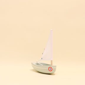 Model sailboat on a beige background