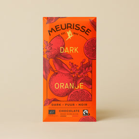 Meurisse Dark Orange chocolate bar in bright orange packaging with illustrated oranges and leaves, labeled ‘Dark Orange,’ standing upright against a soft beige background.