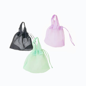 Three drawstring bags in black, green, and pink on a white background