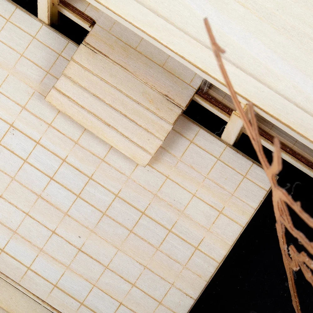 Close-up of a model building with tiled roof and wooden structure