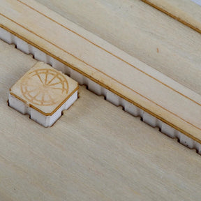 Small wooden block with a circular design on a larger wooden surface