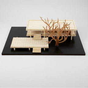 Model of a modern architectural design with a large coral-like sculpture on a black platform.