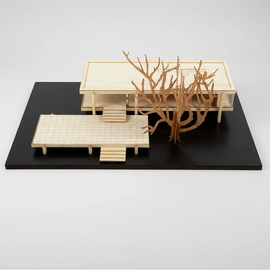 Model of a modern architectural design with a large coral-like sculpture on a black platform.