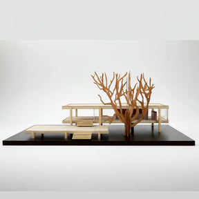 Wooden architectural model of a modern building on a black platform with a white background