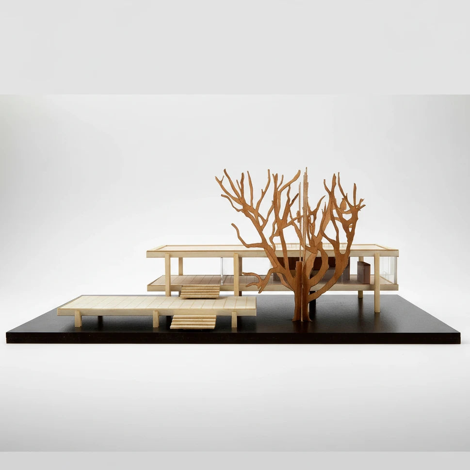 Wooden architectural model of a modern building on a black platform with a white background