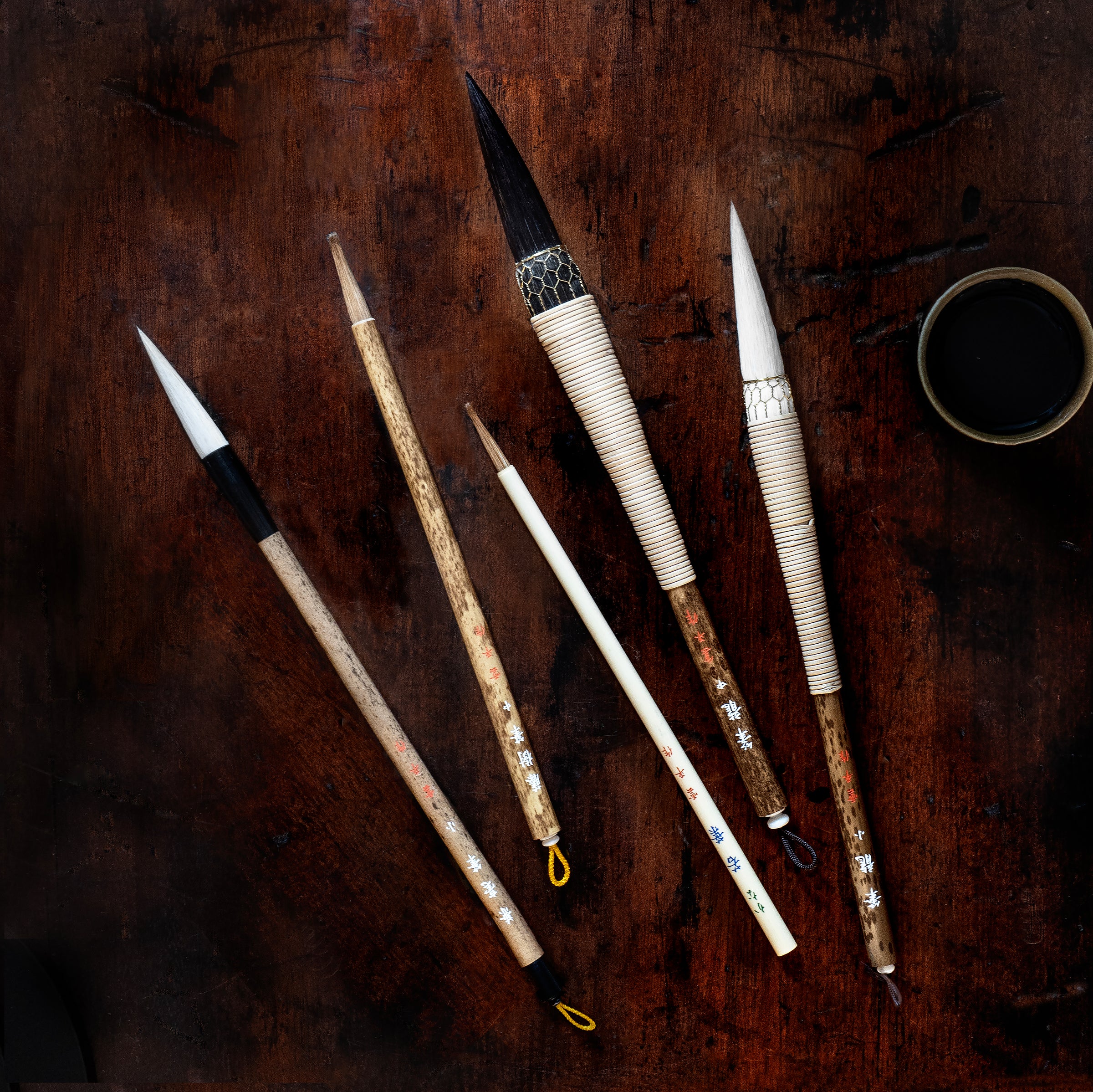 Set of calligraphy brushes on a wooden surface