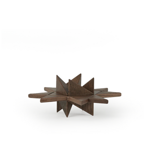 Geometric wooden star-shaped object crafted from smoked wood, composed of intersecting flat planes and pointed facets, showcasing rich dark wood grain and a sculptural matte finish on a plain white background.