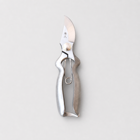 A silver metal pruning knife with a polished blade and textured handle, shown vertically against a light gray background.