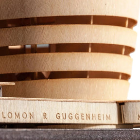 Close-up of a wooden architectural model with 'Solomon R Guggenheim Museum' branding.