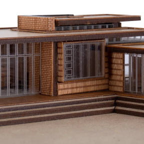 Model of a modern architectural design with wooden exterior and glass windows.