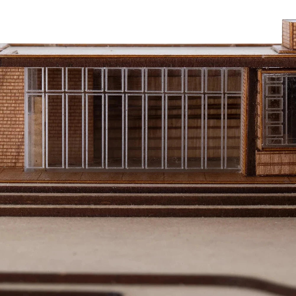 Model of a building with a brick facade and large windows on a white background