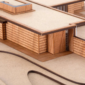 Model of a modern architectural design with wooden textures and glass panels.