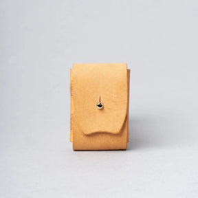 Tan leather pouch with a metallic clasp on a light gray background